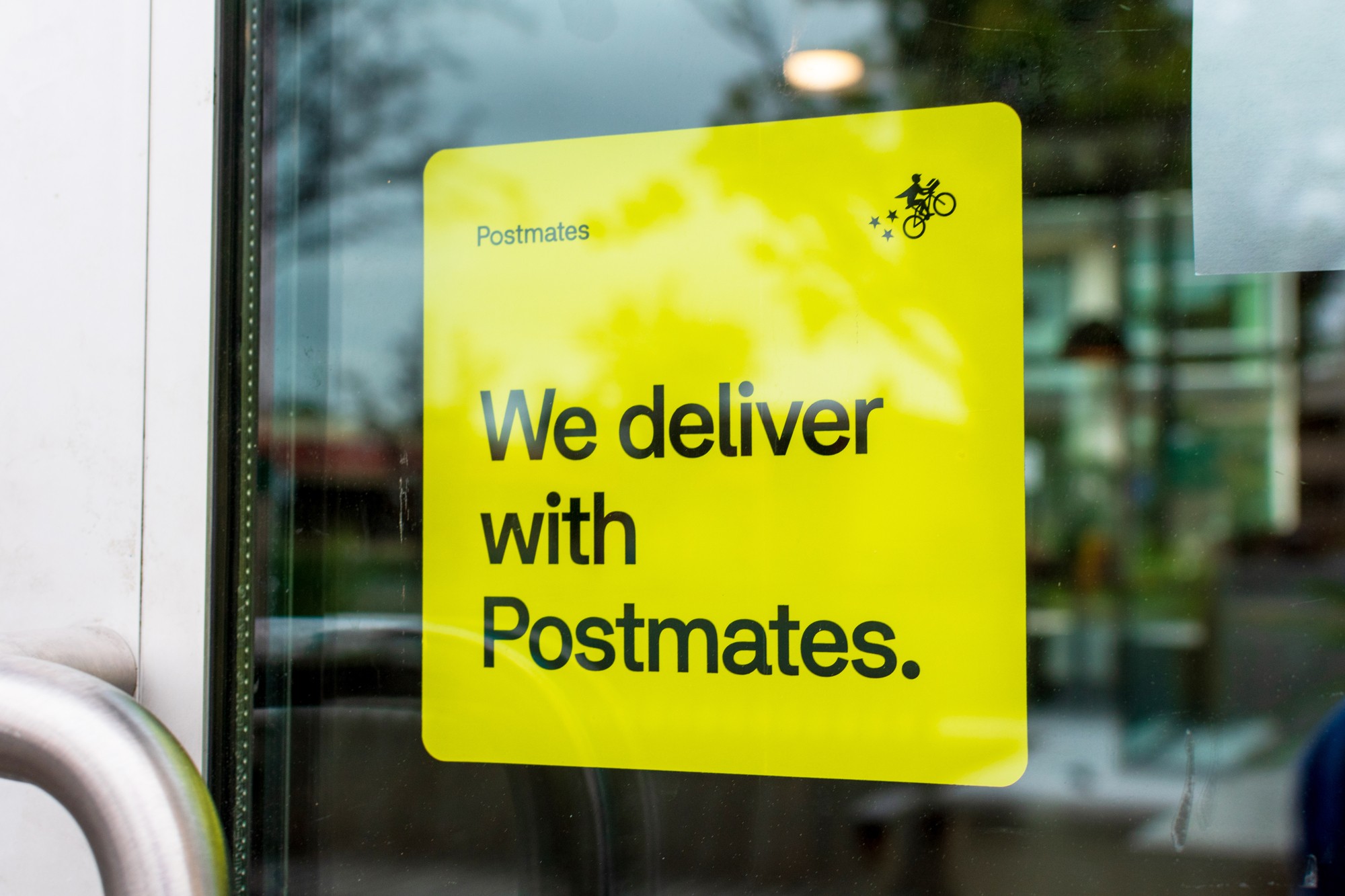 A yellow sticker decal advertising Postmates delivery service